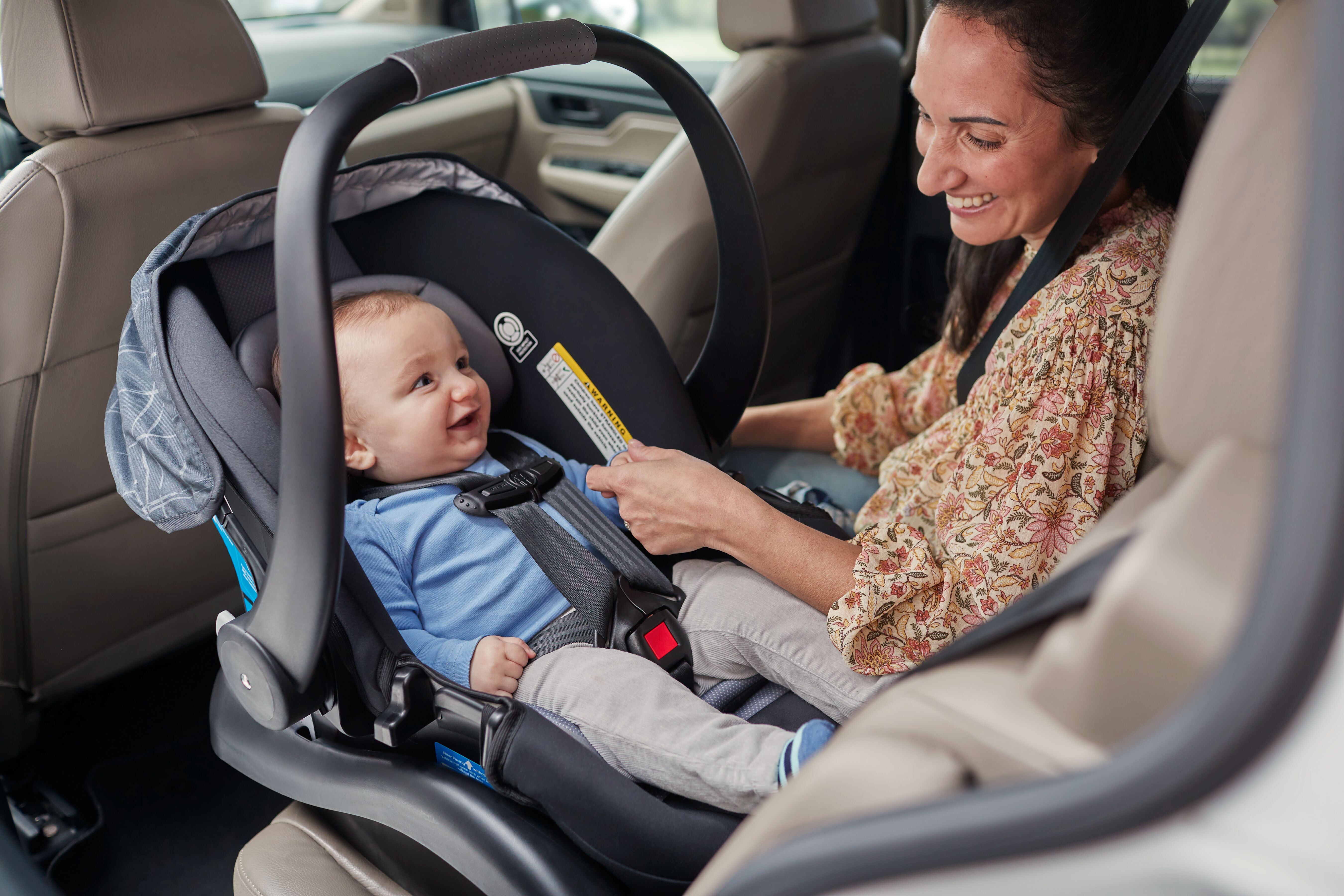 mom smiling at baby in infant car seat