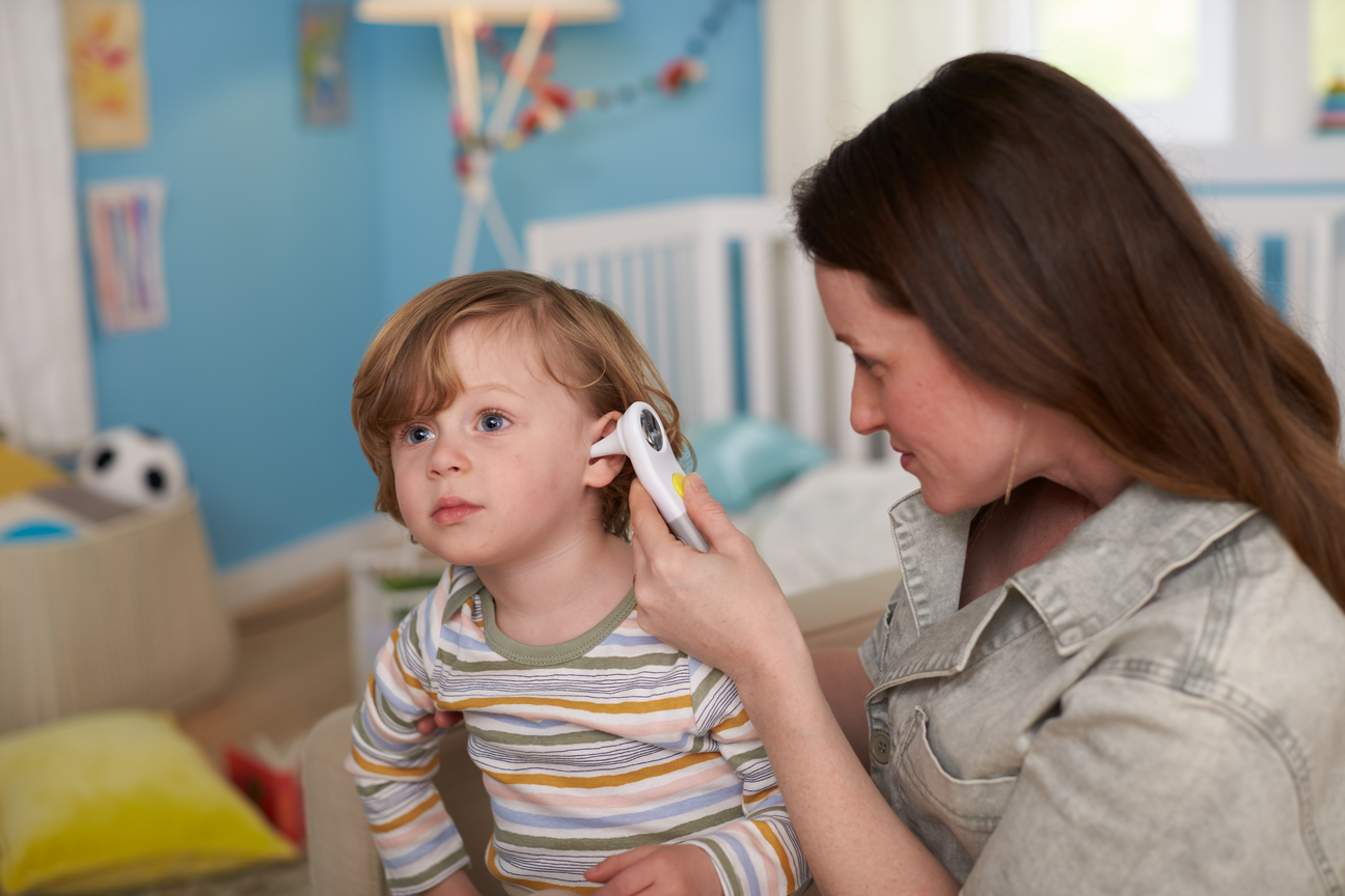 mother using ear otoscope on child