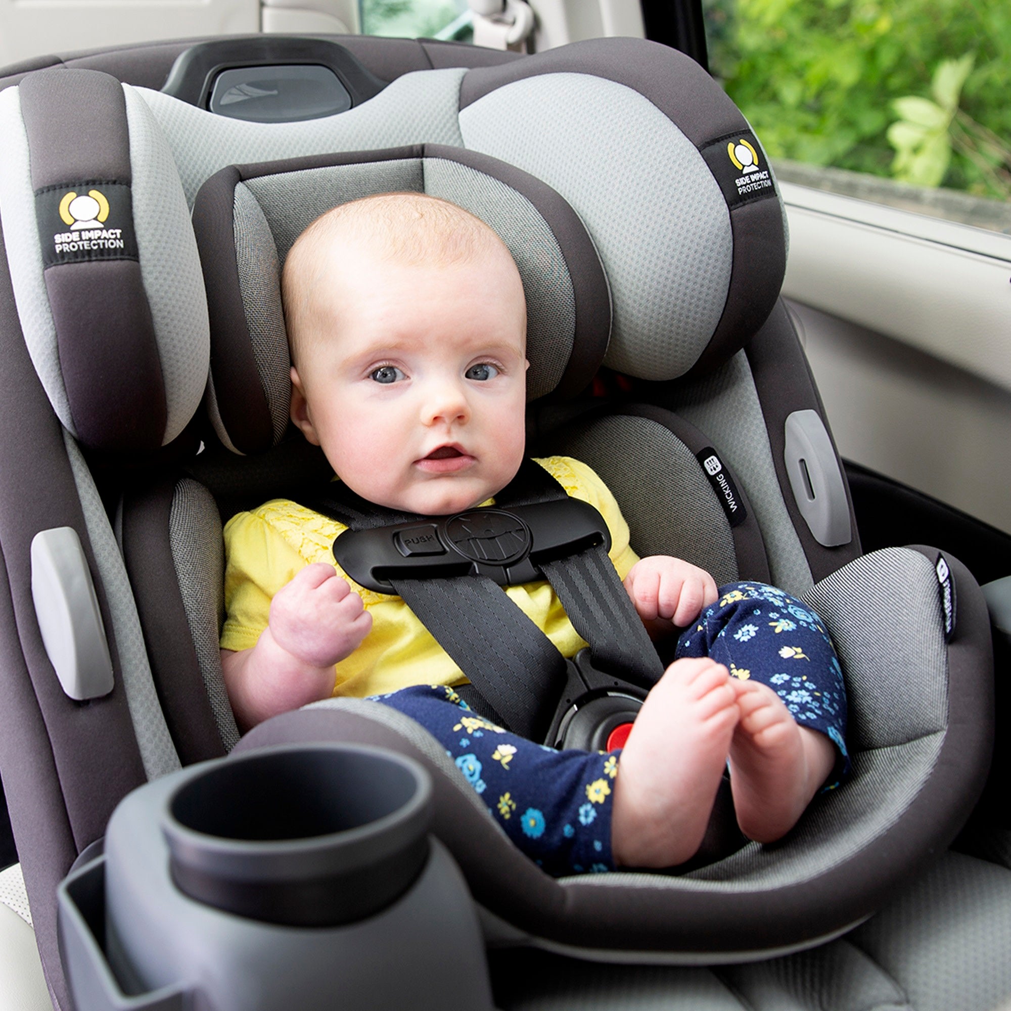 baby wearing yellow shirt in car seat
