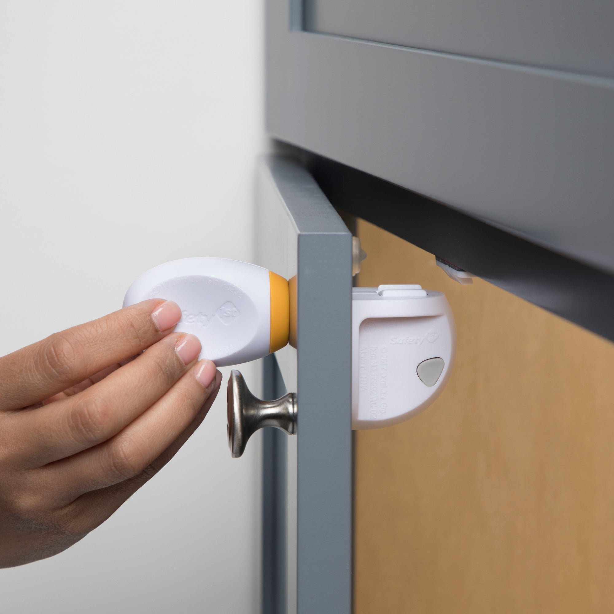 Magnetic cabinet lock being demonstrated on a cabinet