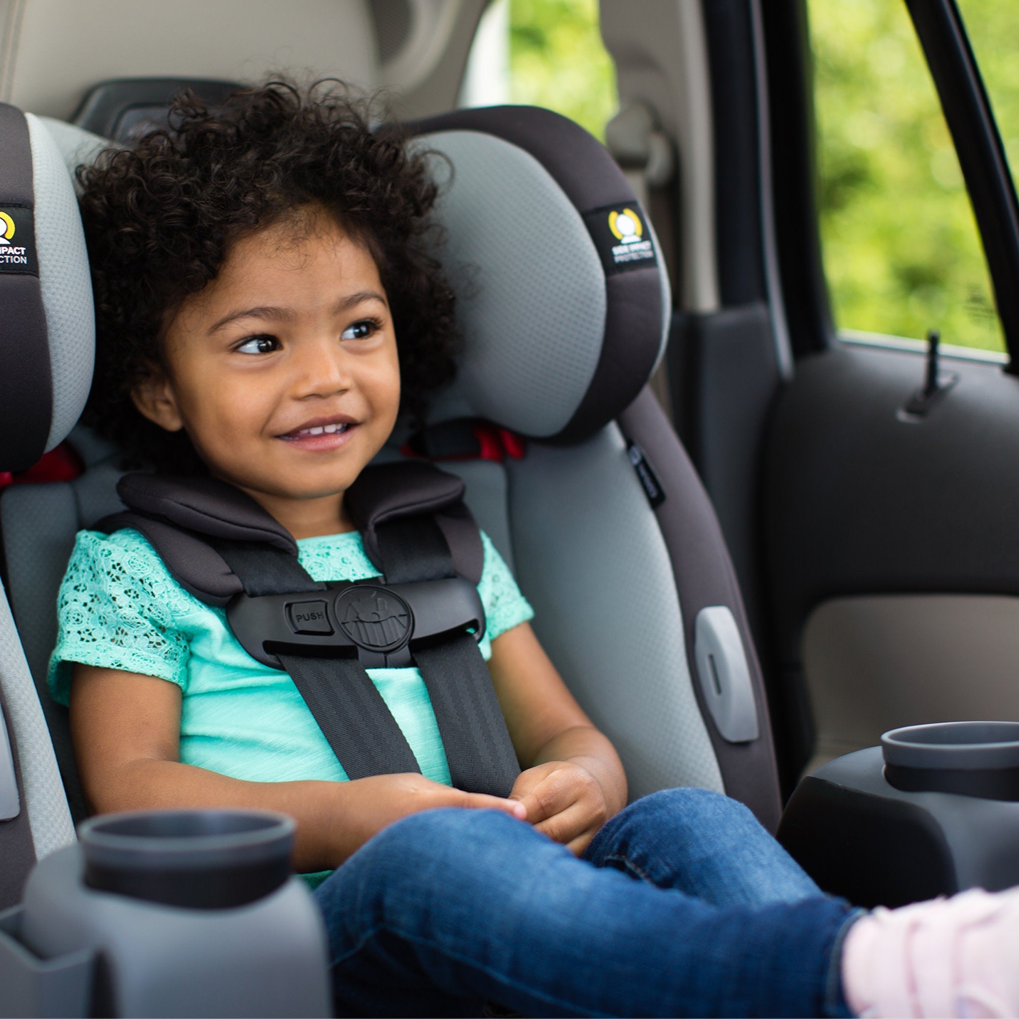 smiling toddler in convertible car seat in car