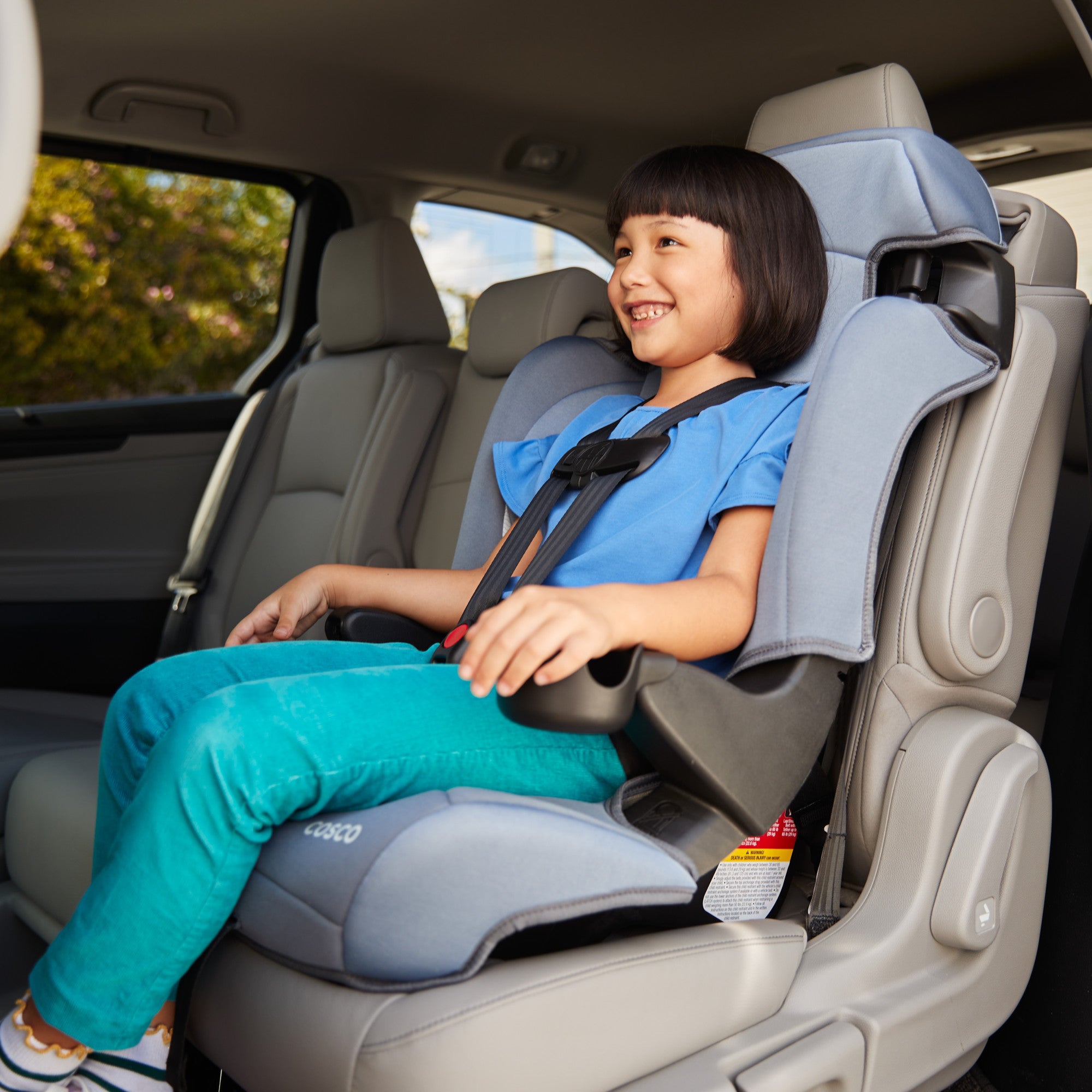 Cosco Kids™ Finale DX 2-in-1 Booster Car Seat - 45 degree angle view of child smiling in car seat