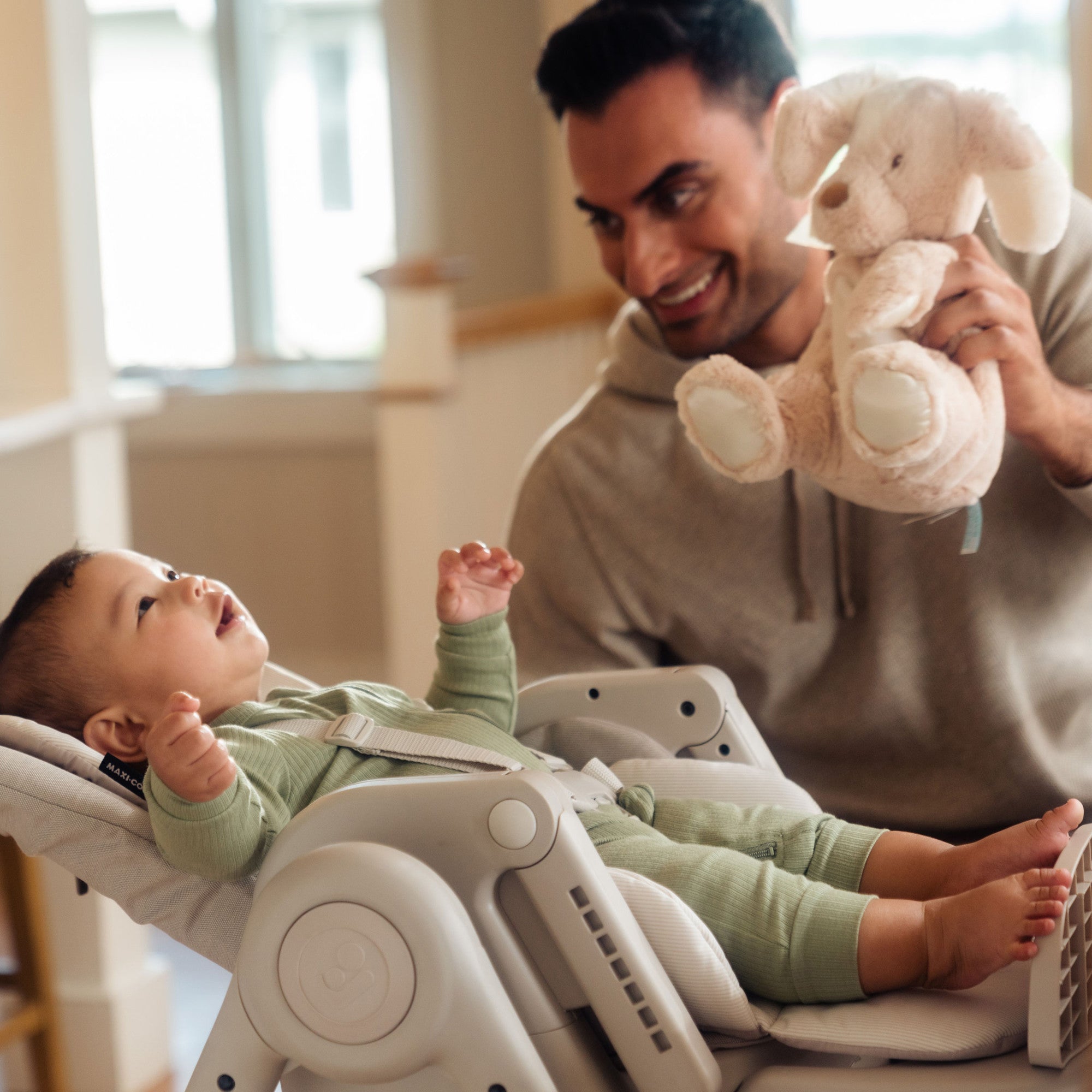 Minla 6-In-1 High Chair - baby reclining in high chair and father entertaining him with stuffed animal
