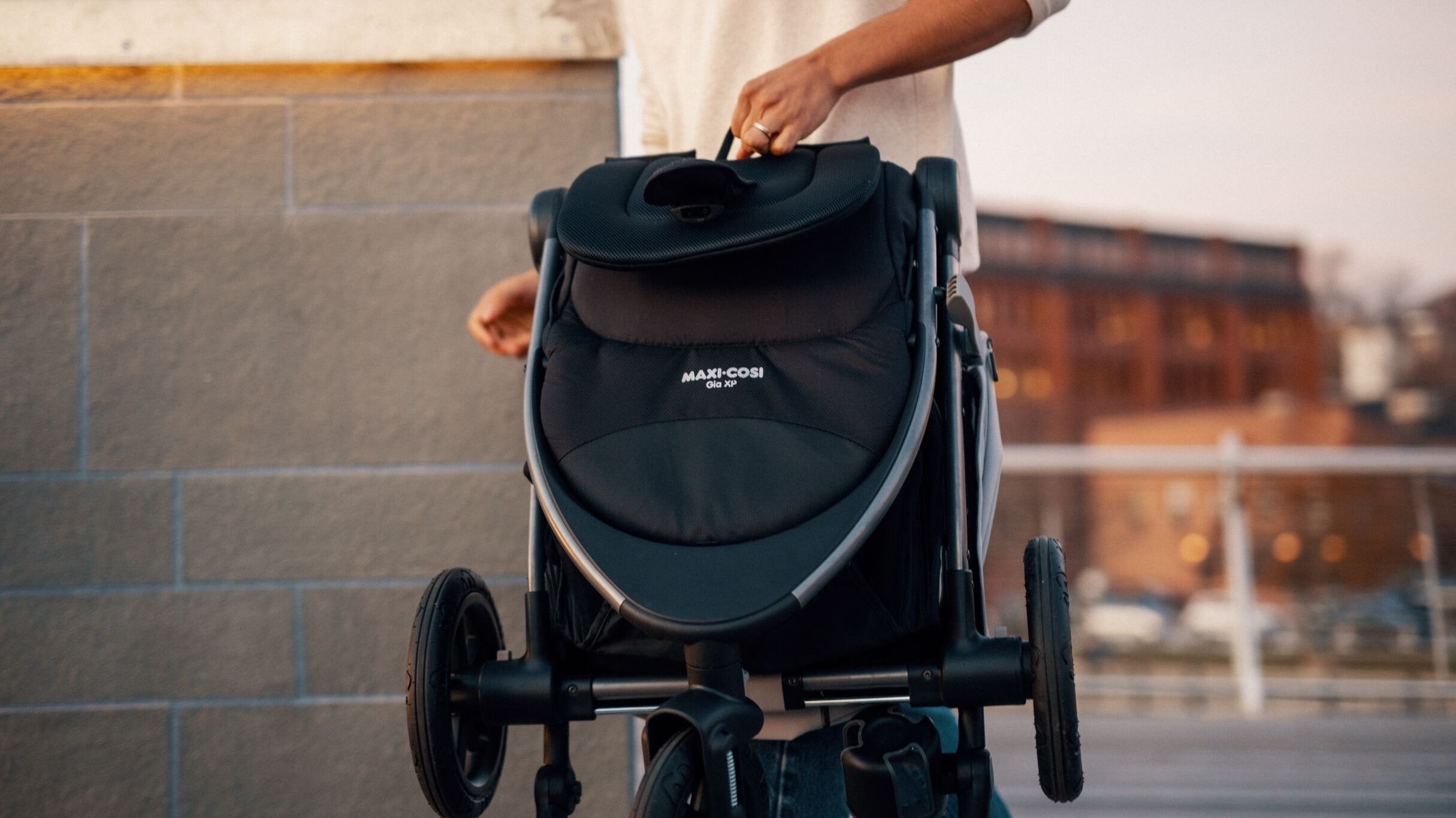 father carrying folded Gia stroller