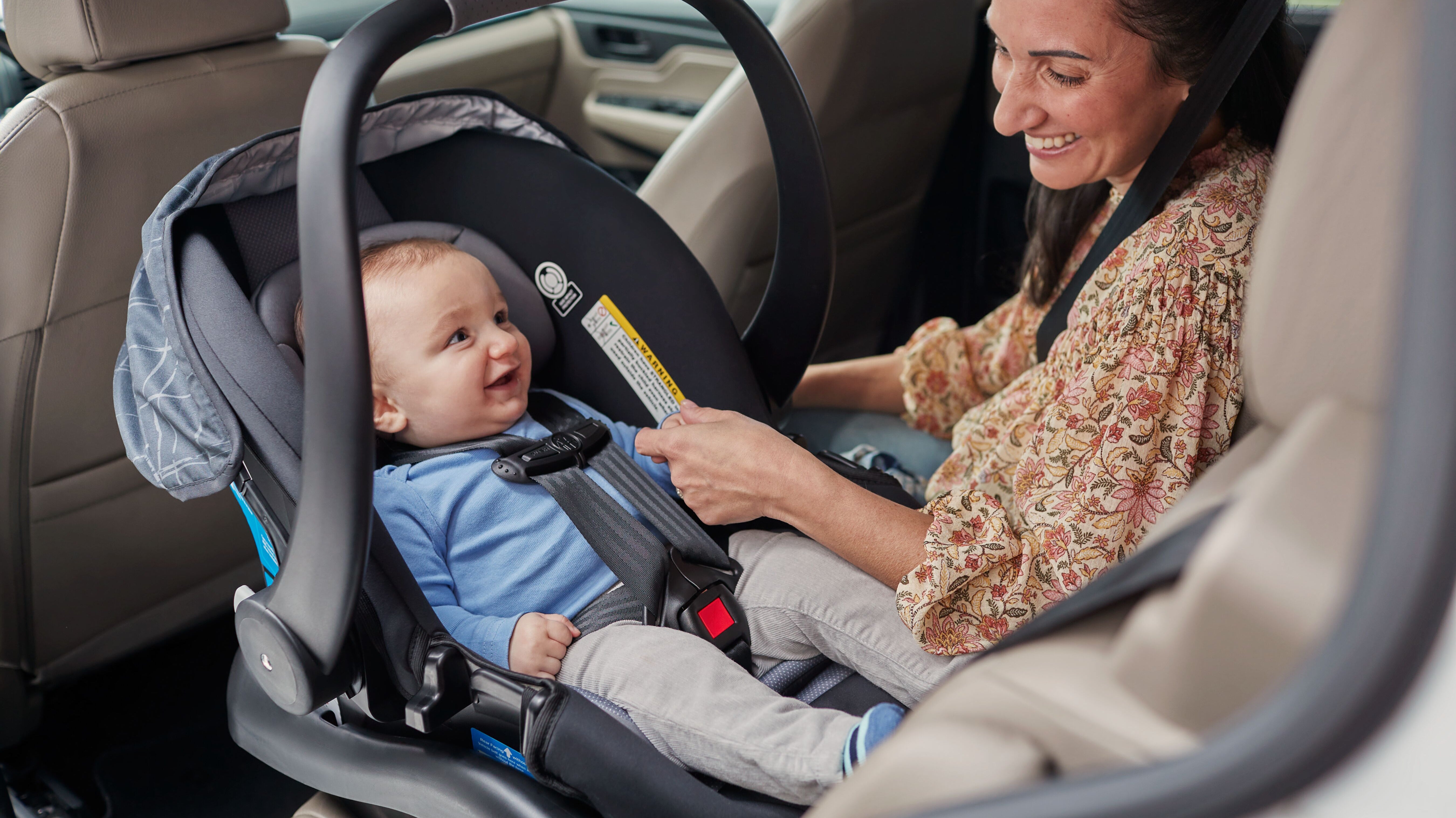 mom smiling at baby in infant car seat