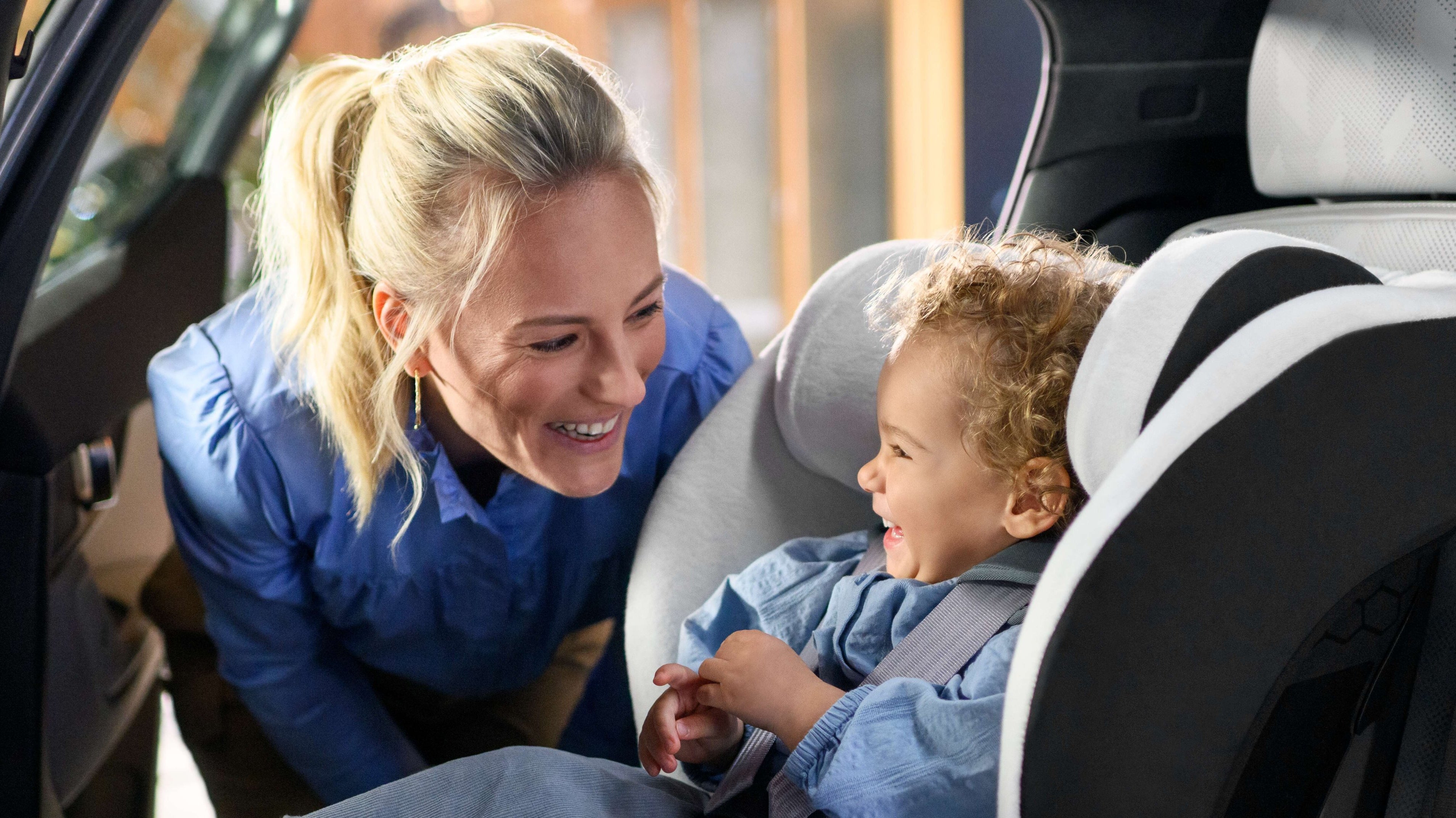 mother smiling at child in car seat