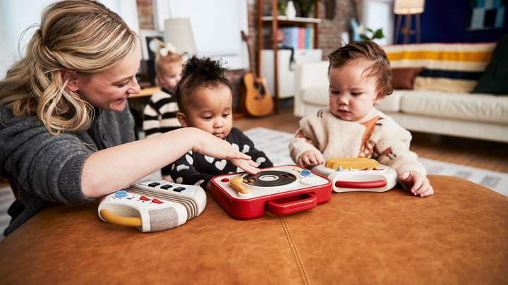 woman playing with toddlers and their Tiny Love instruments