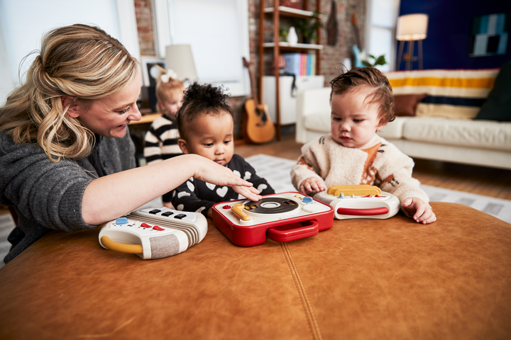woman playing with toddlers and their Tiny Love instruments