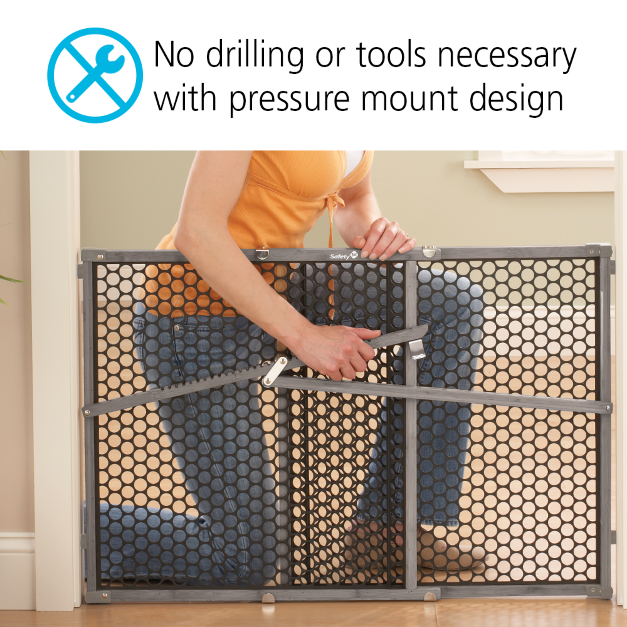 Parent demonstrating baby gate no drilling or tools necessary with pressure mount design.