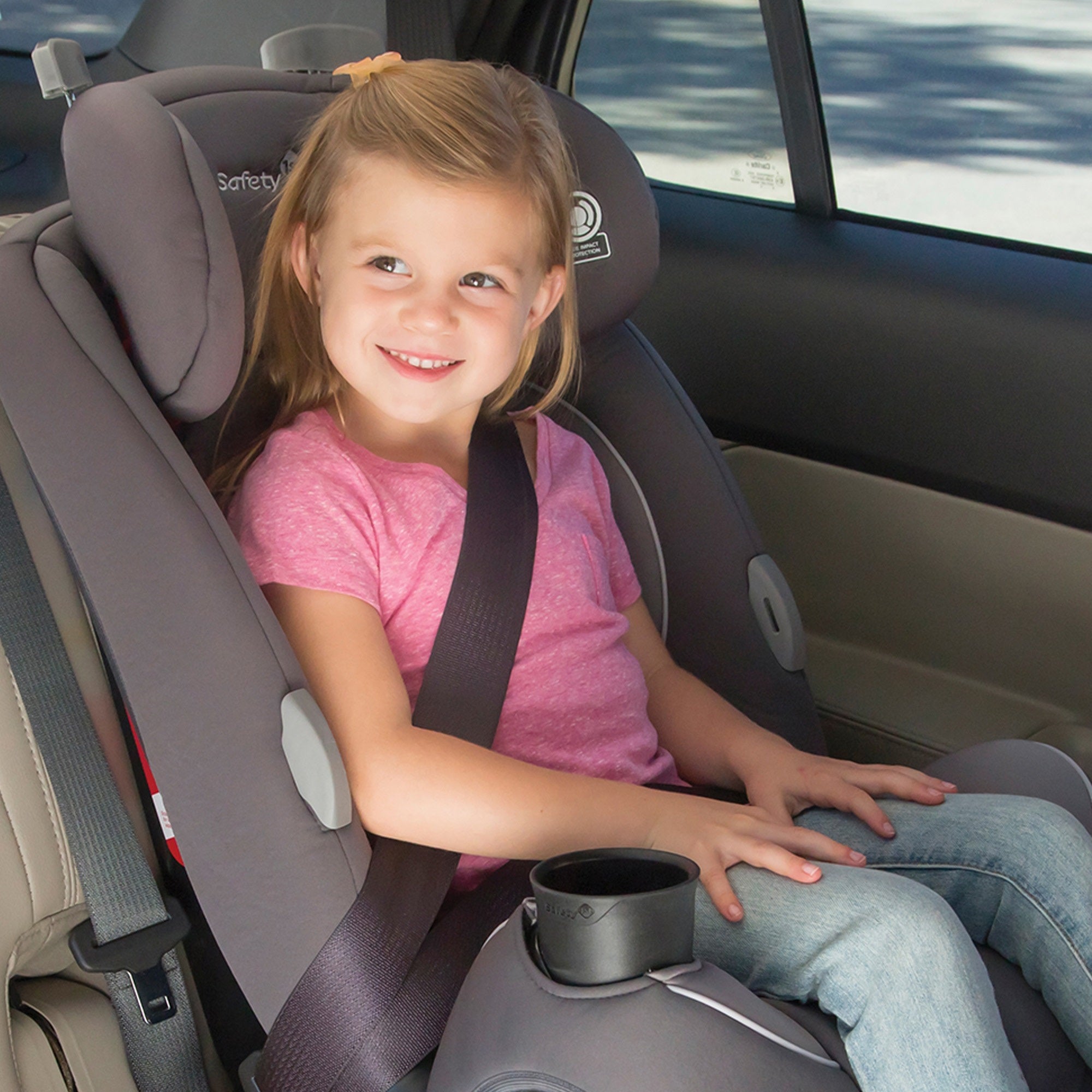 toddler girl in pink shirt sitting in convertible car seat with vehicle belt