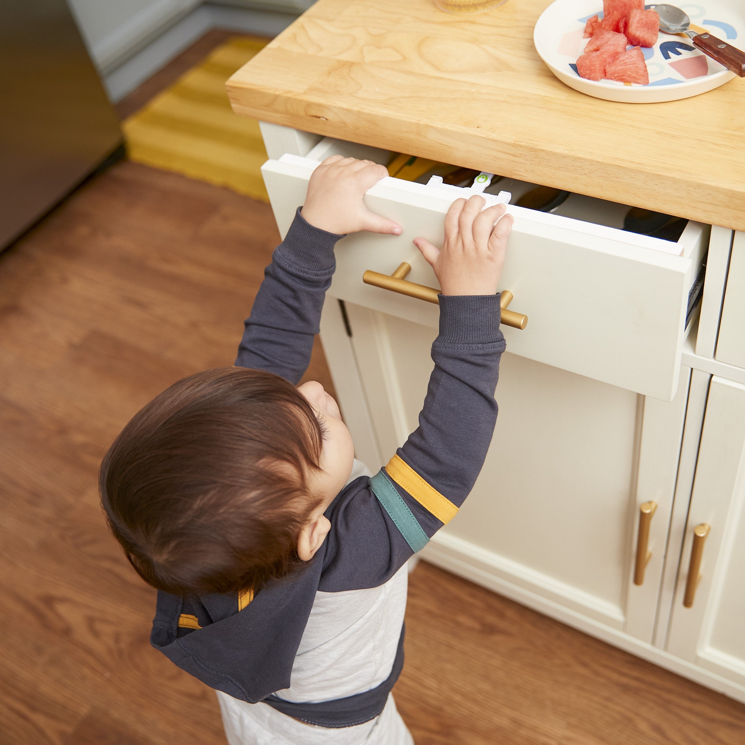 Secure-to-Explore Adhesive Locks - boy attempting to open drawer