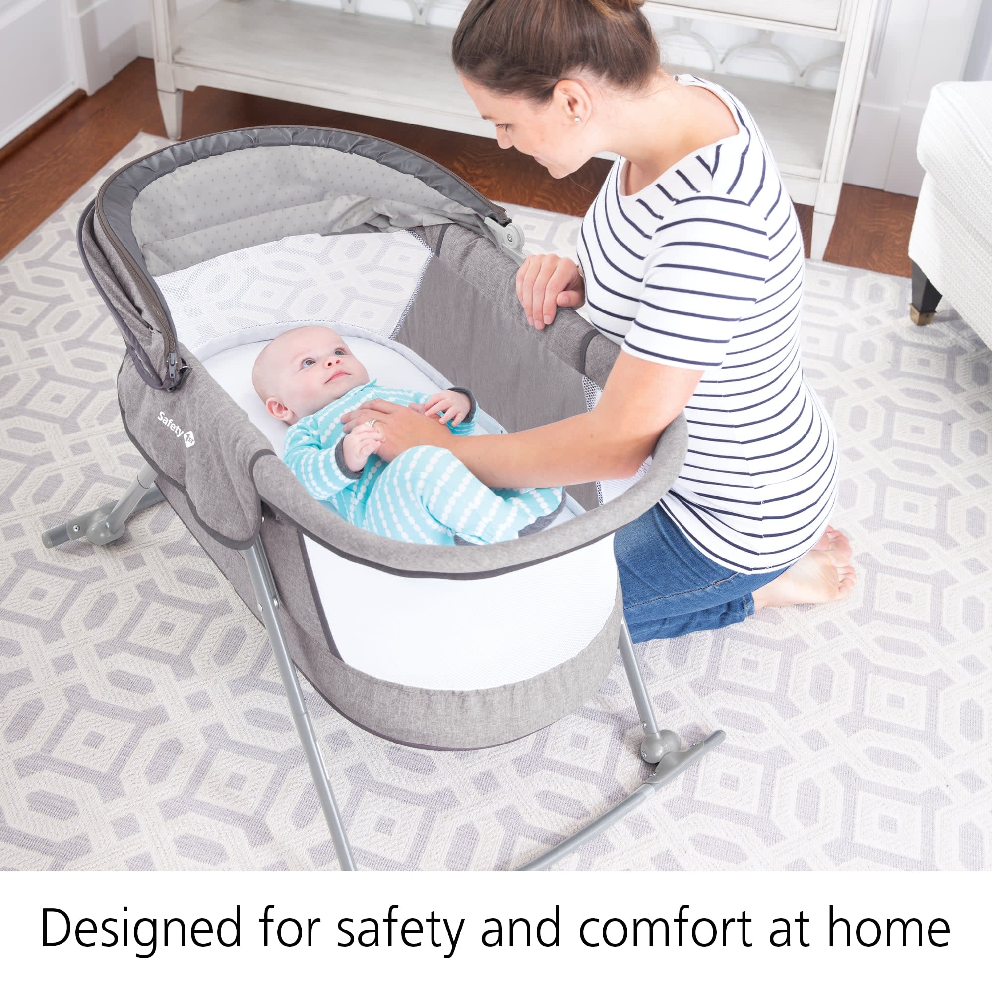 Parent with a baby in a nursery showing how the bassinet is designed for safety and comfort at home