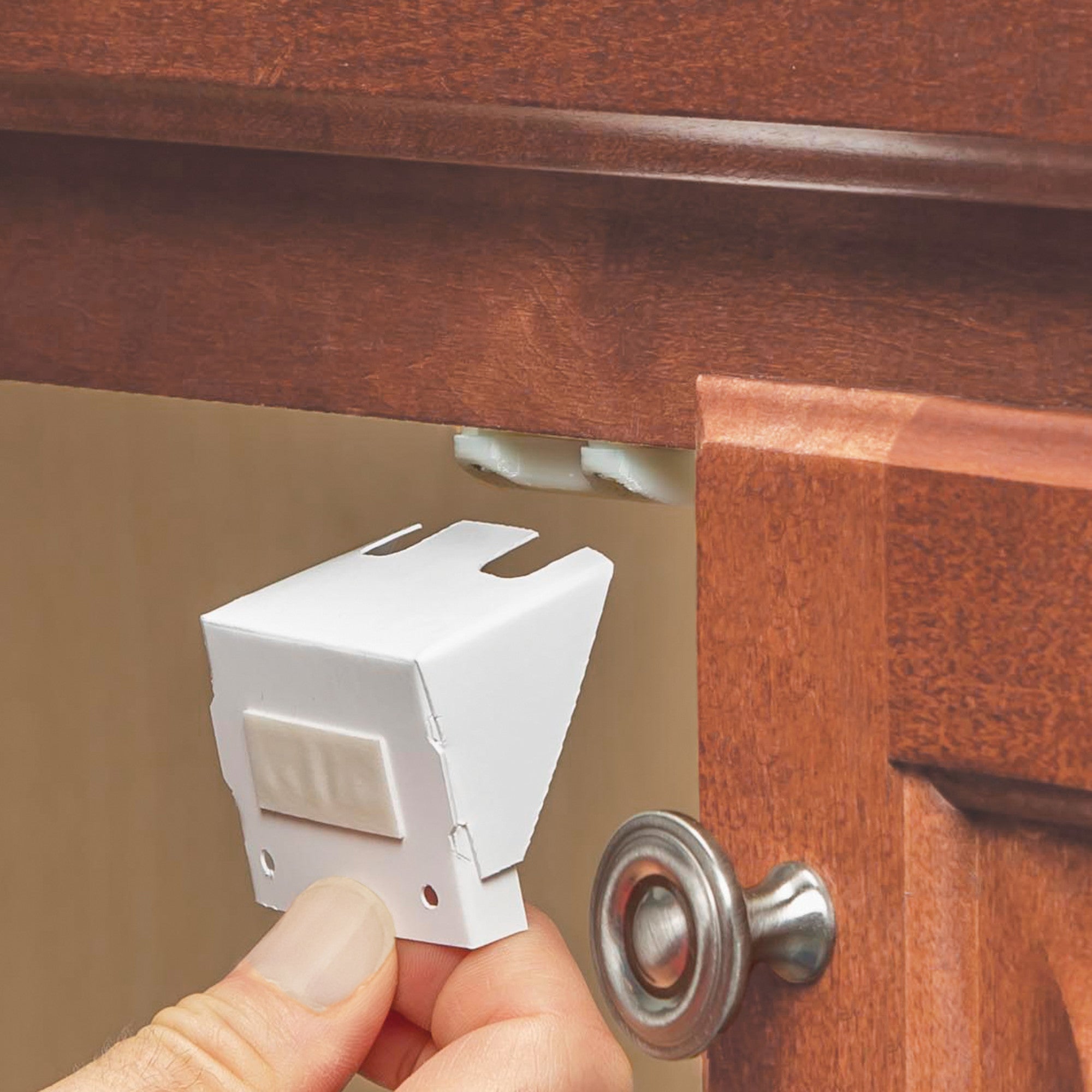 Cabinet latch being installed on a cabinet