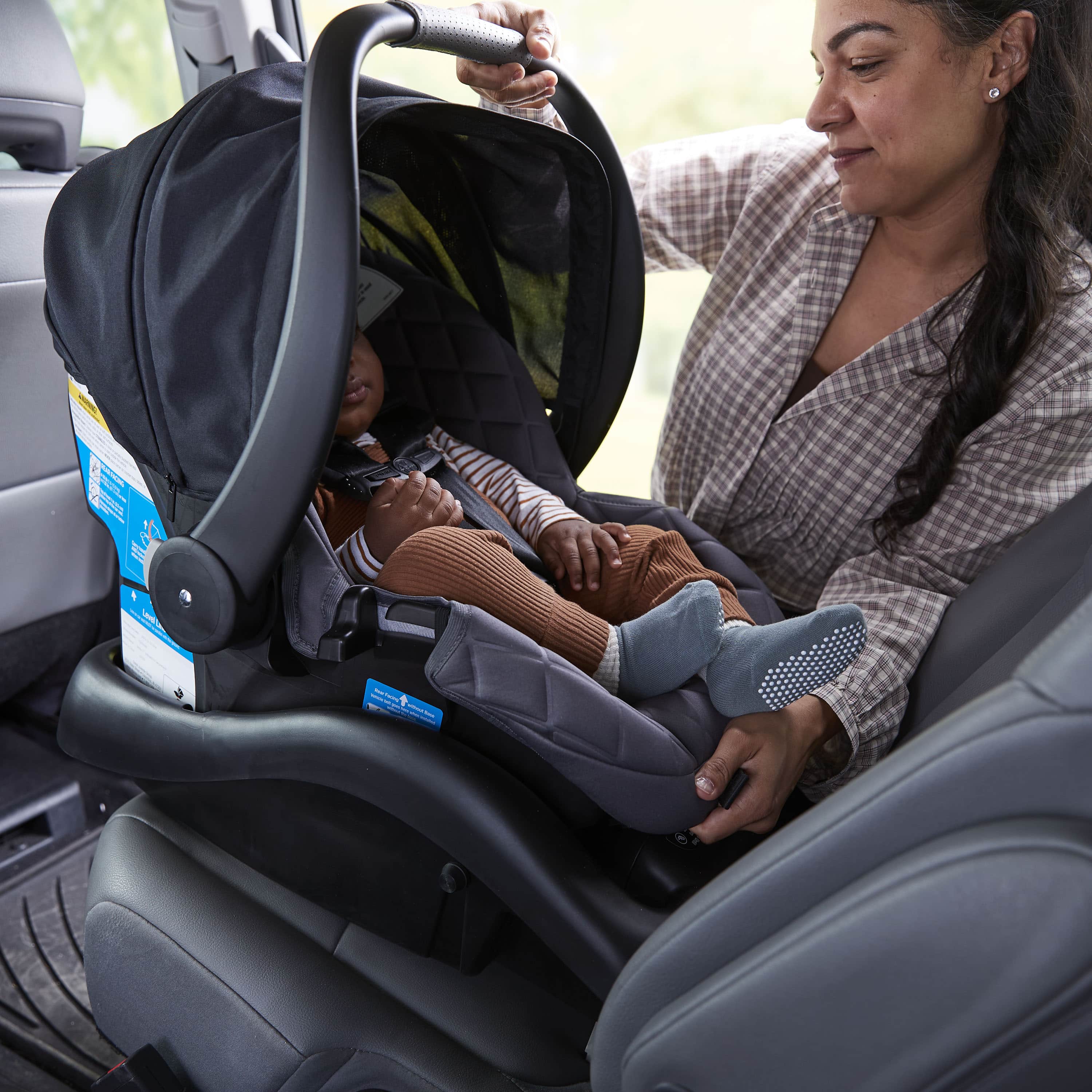 onBoard™ Insta-Latch™ DLX Car Seat - mother putting baby in car seat in the car