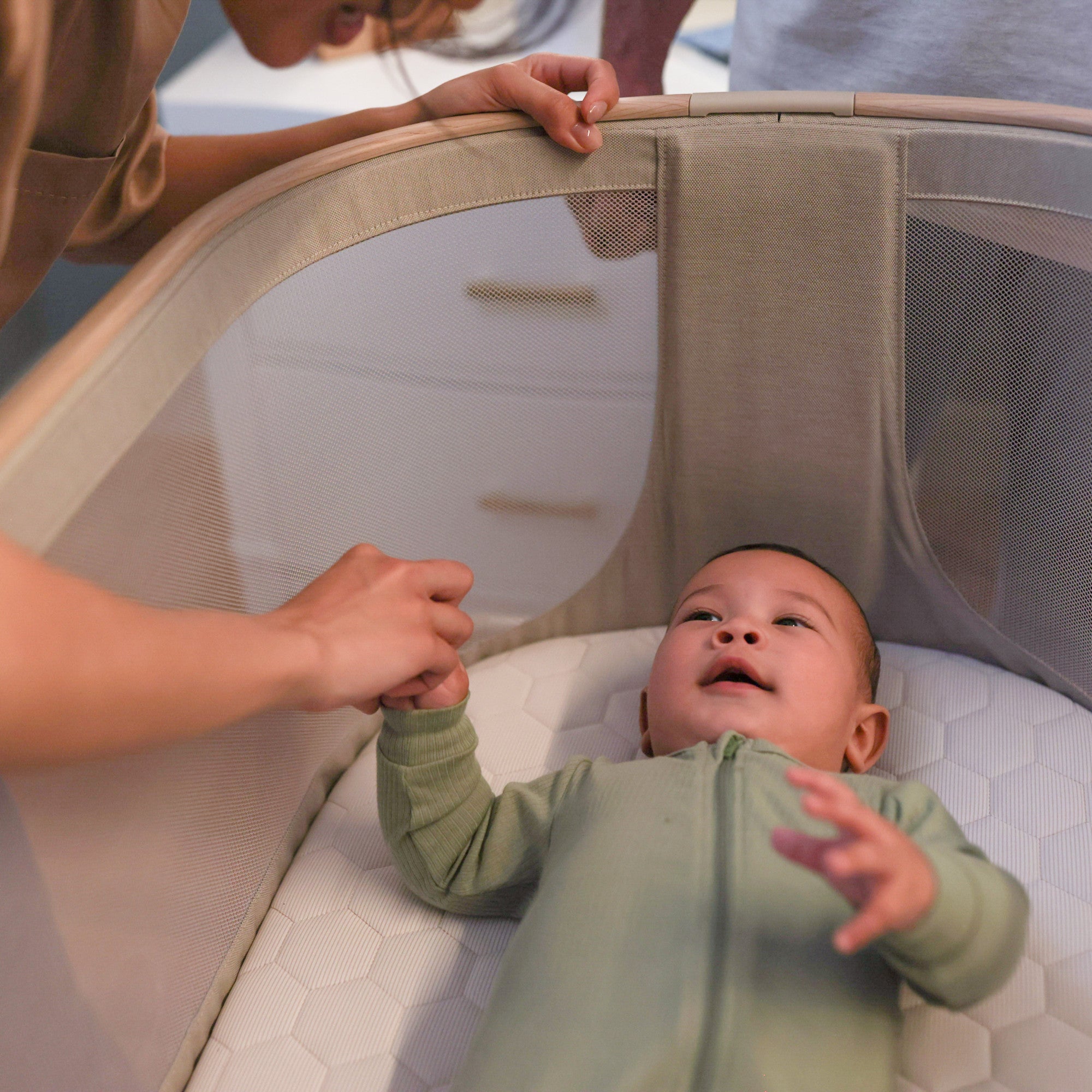 Iora Bedside Bassinet - mother doting on baby in bassinet