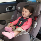 baby in pink shirt and socks in convertible car seat