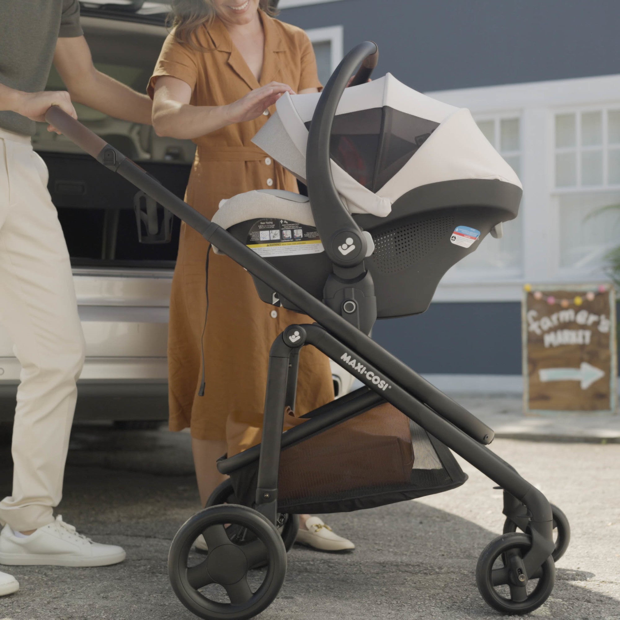 Tayla™ Max Travel System - mother and father looking at baby with Tayla Max in reversible stroller mode
