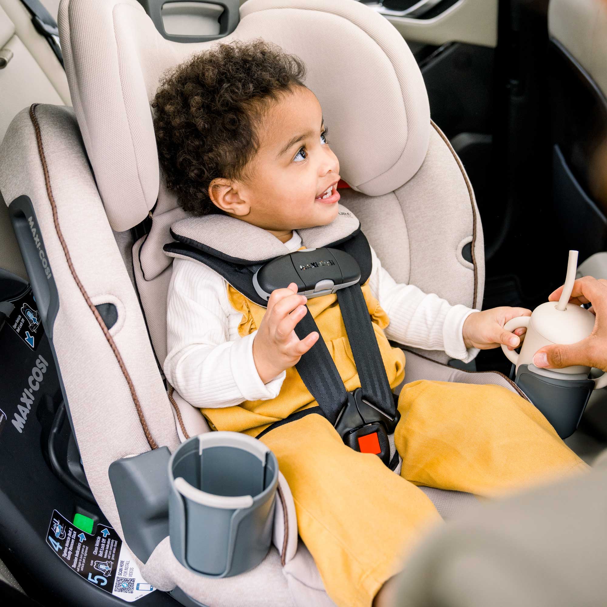 Emme 360™ Rotating All-in-One Convertible Car Seat - child in car seat holding cup that's in cupholder