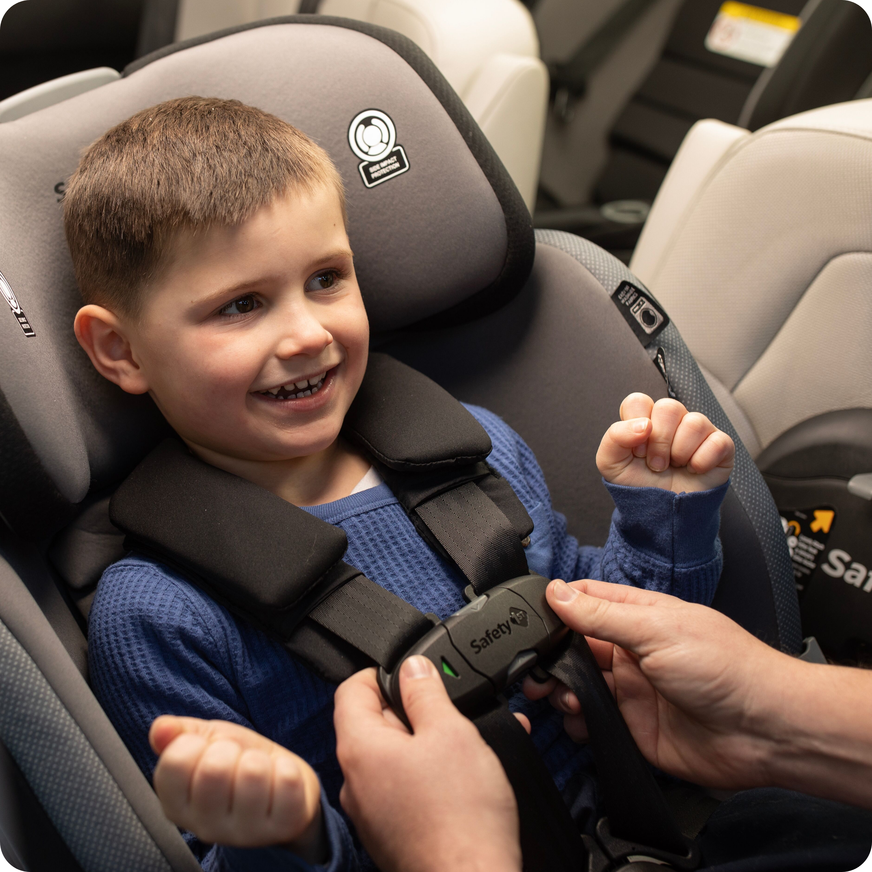 Turn and Go 360 DLX Rotating All-in-One Convertible Car Seat - boy being harnessed in to car seat