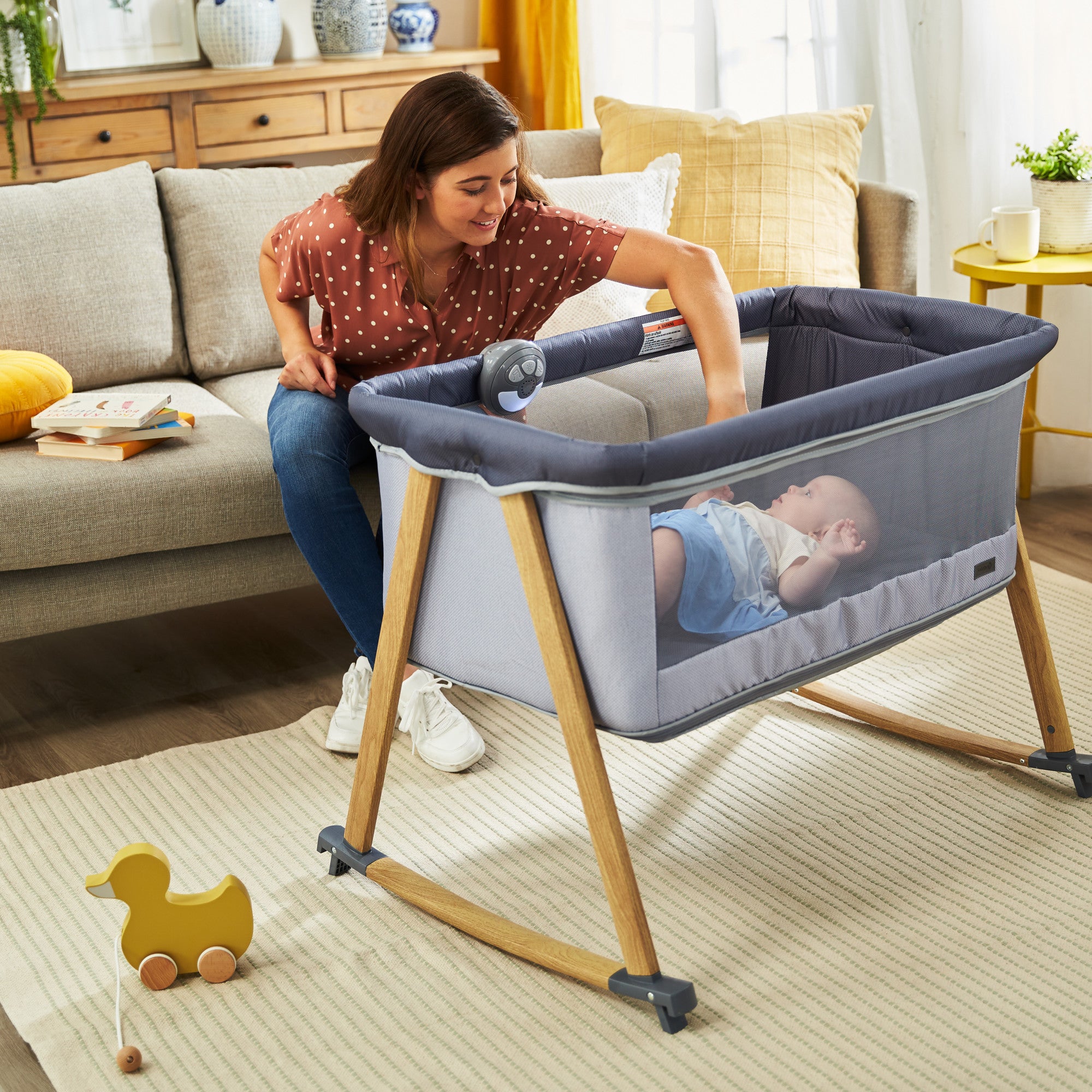 Rest-and-Romp Play Yard - mother doting on baby in bassinet mode