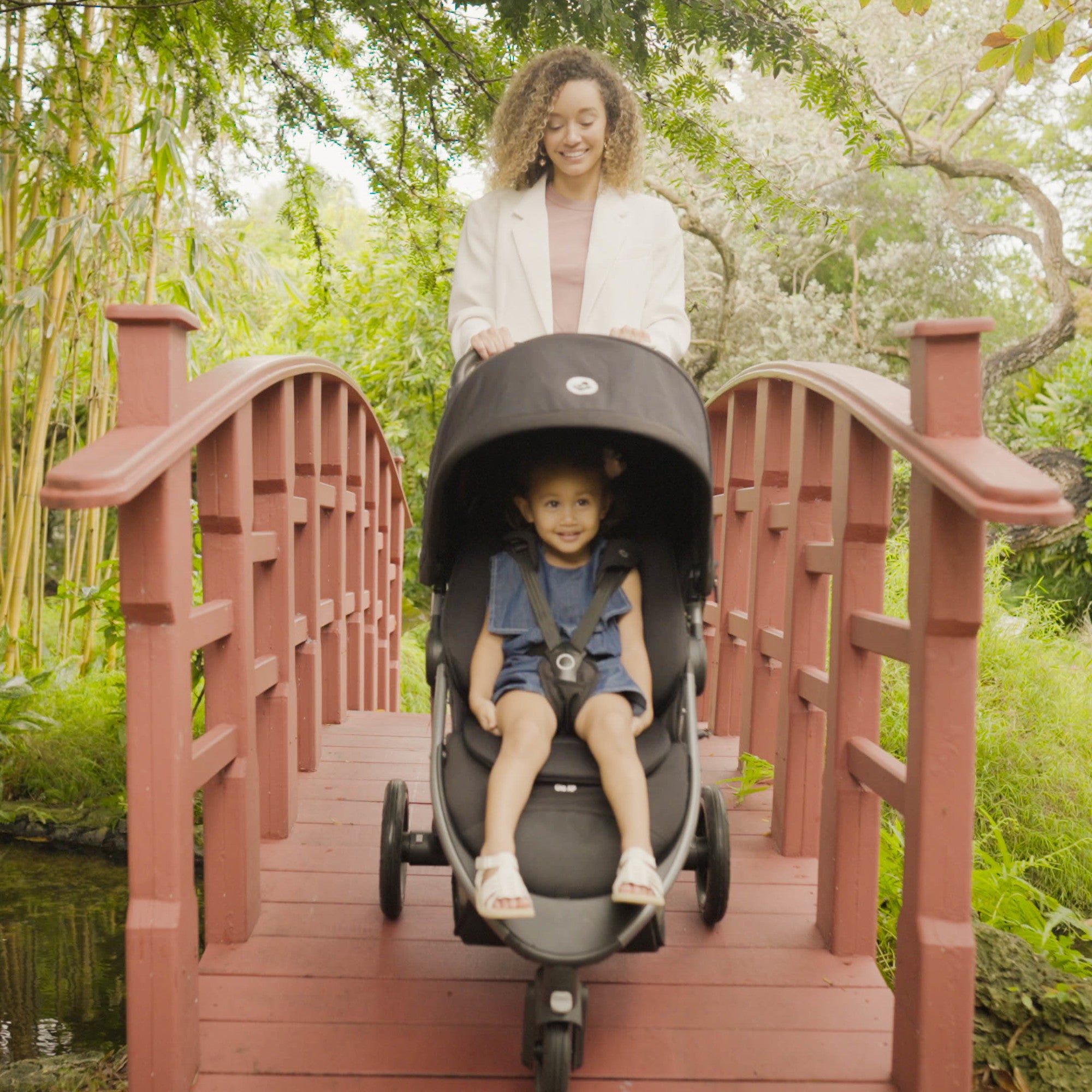 Gia XP Luxe 3-Wheel Travel System - mother walking child in forward facing stroller mode