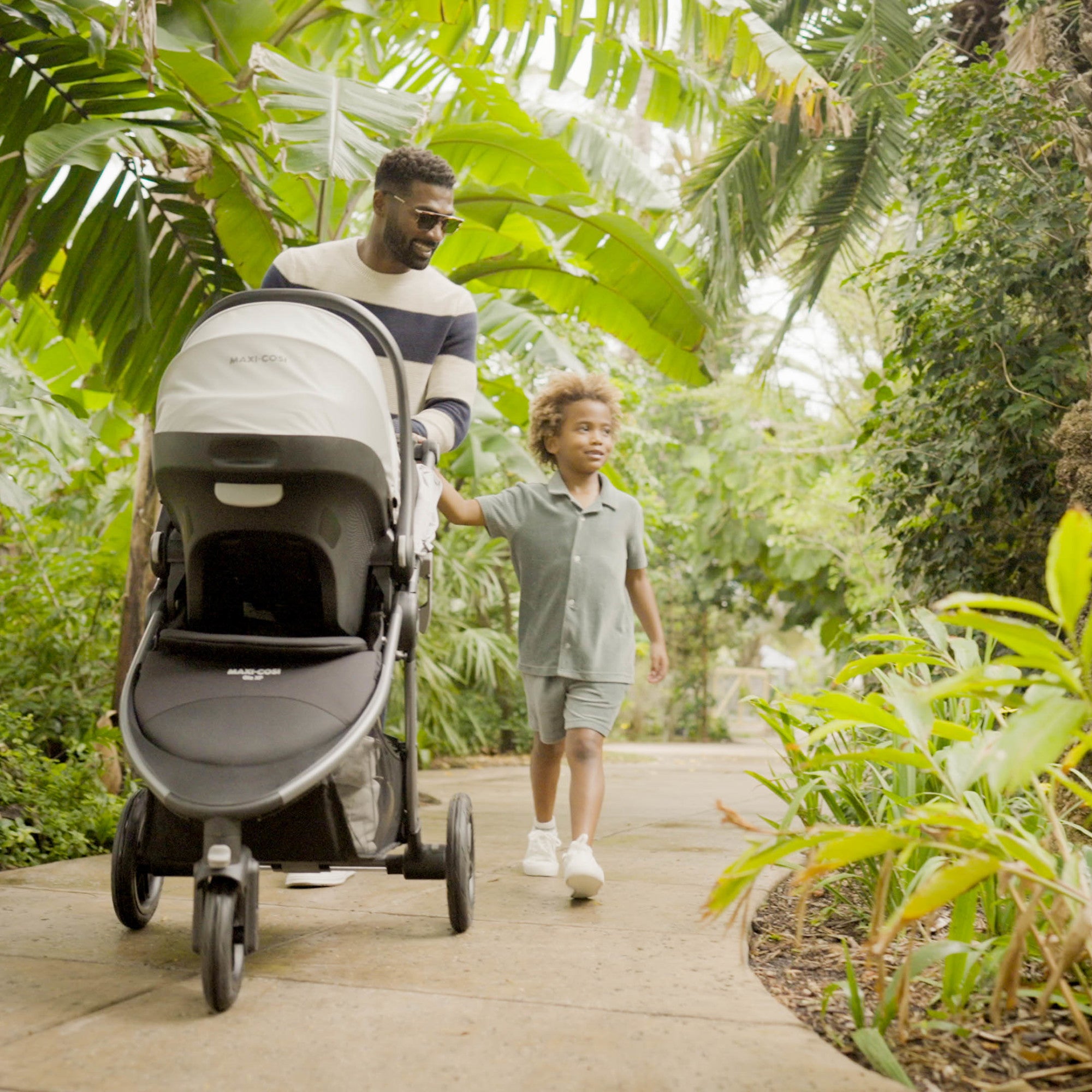 Gia XP Luxe 3-Wheel Travel System - father and child strolling with baby in rear facing stroller mode