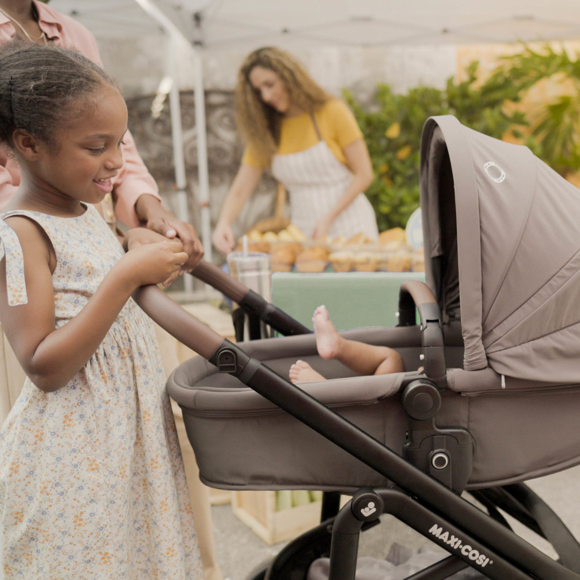 Tayla™ Max Travel System - girl looking at baby with Tayla Max in carriage mode