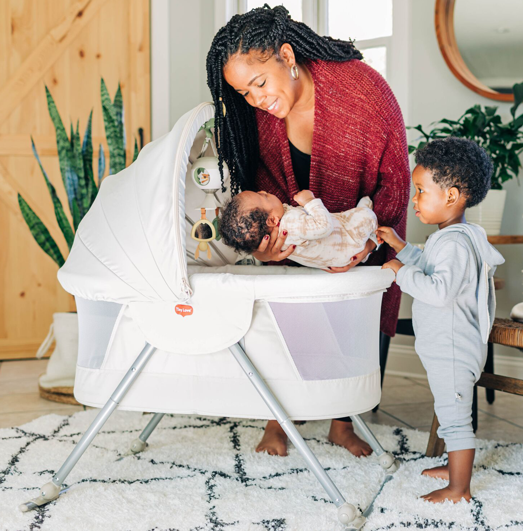 mother putting baby in bassinet